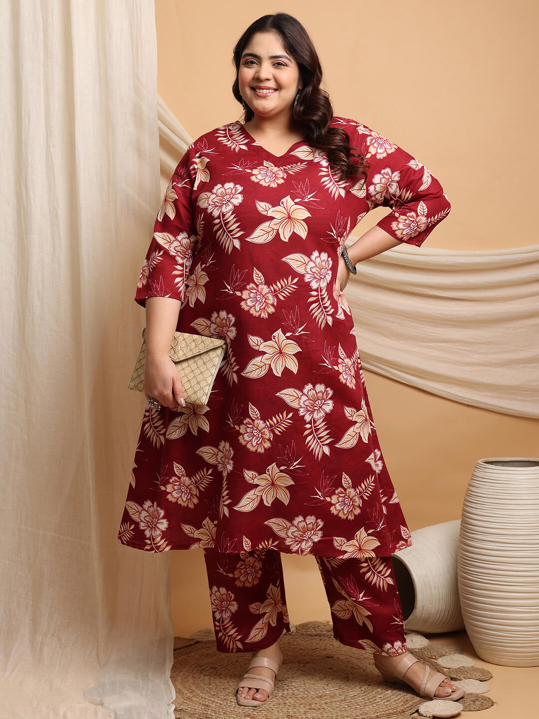 Plus size model in maroon cotton floral kurti pant set holding beige clutch, elegant ethnic plus size outfit – Curvisha