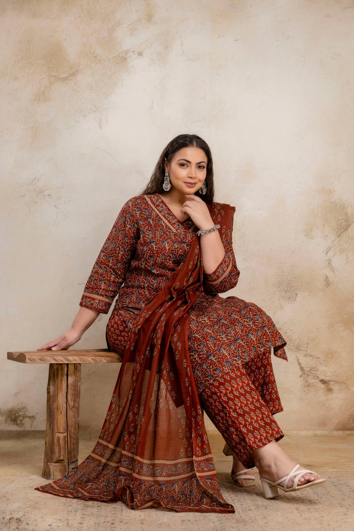 Sitting pose of plus size rust cotton kurti pant dupatta set for fat and curvy women