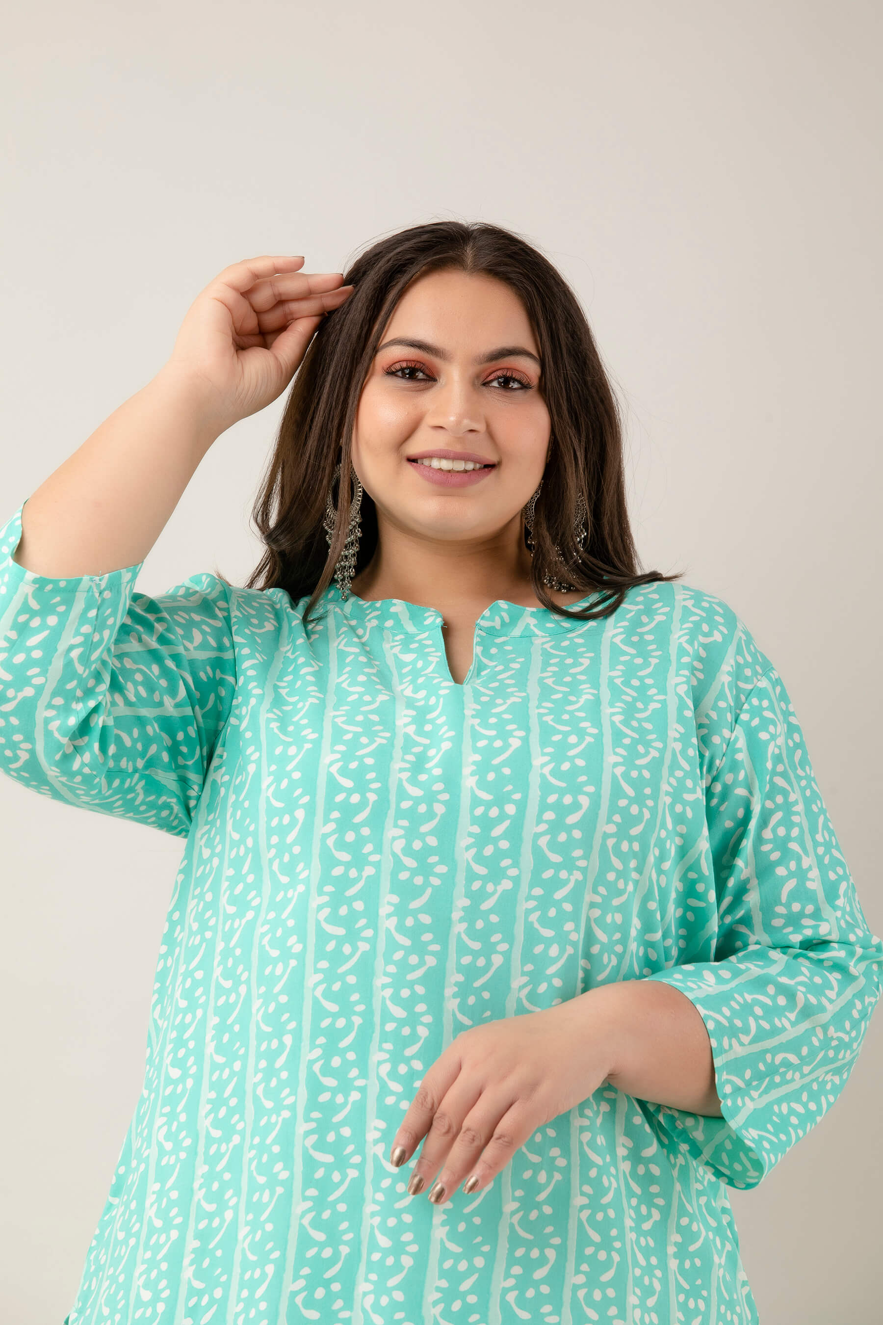 Closeup of vertical vine stripe print on mint rayon; lightweight, breathable fabric; chic pattern for big-size wardrobes.
