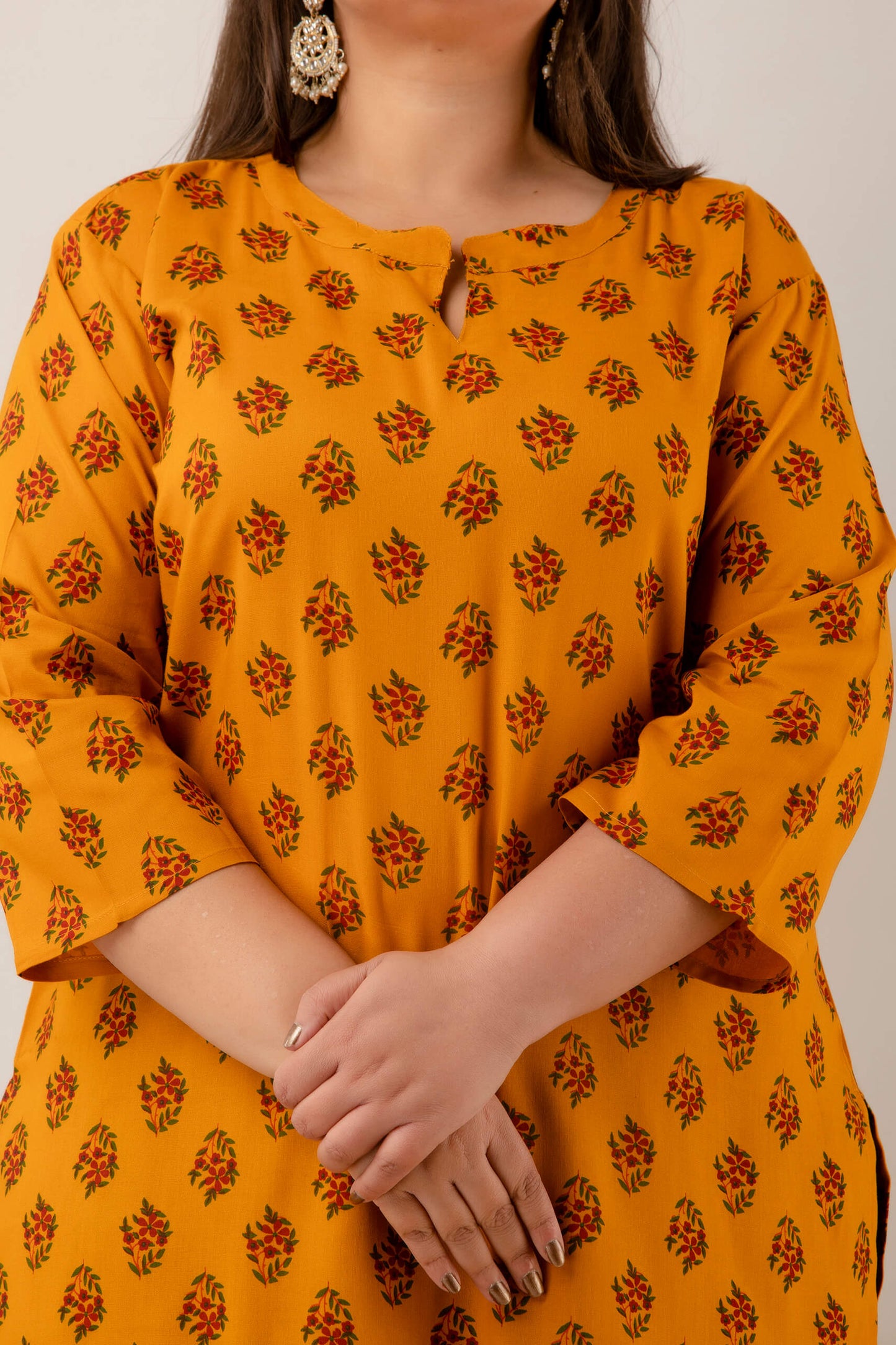 Closeup of floral buta print on mustard rayon; lightweight, breathable fabric; chic ethnic pattern for big-size wardrobes.