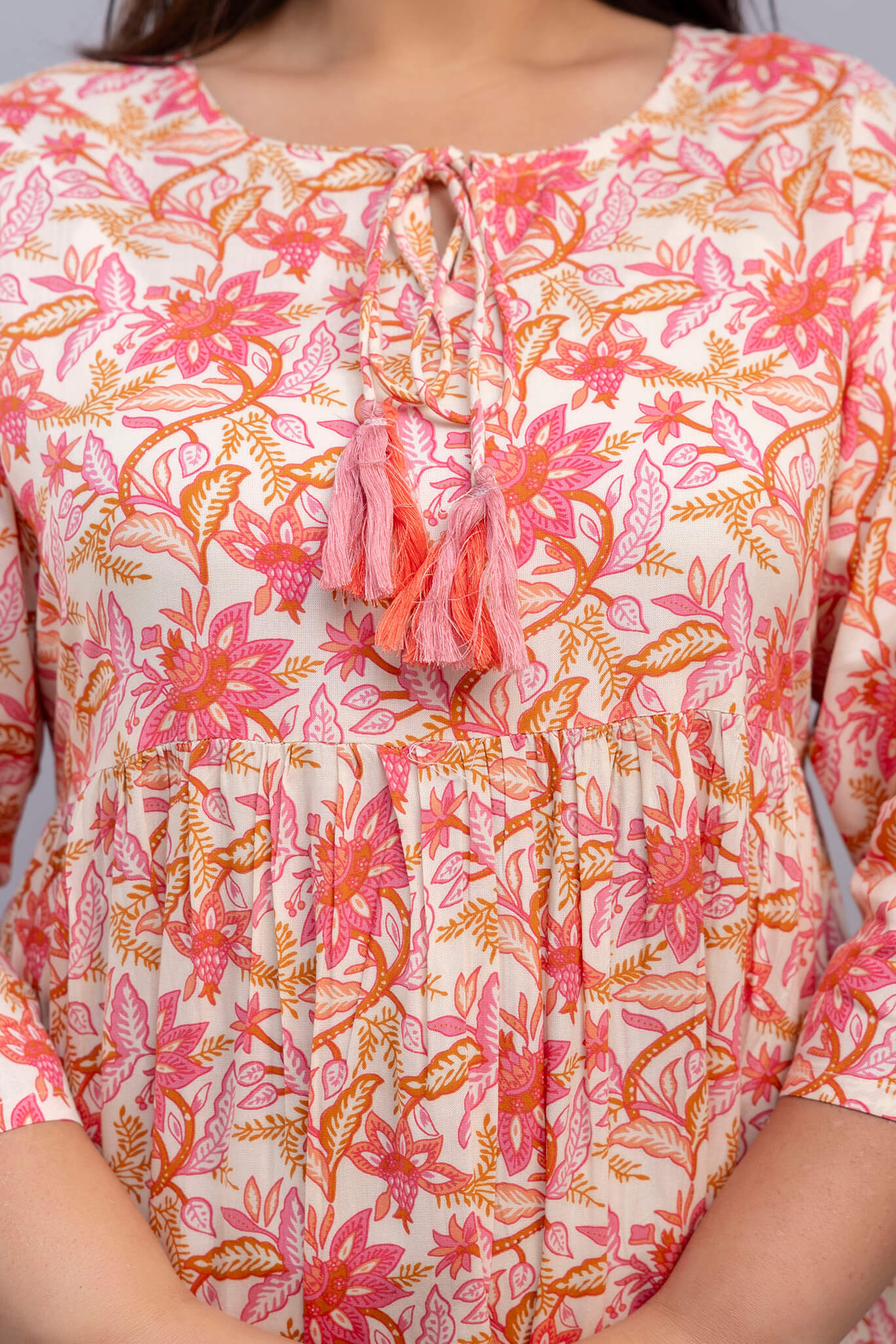 Closeup neckline and tassels on peach pink floral rayon gown for fat plus size fashion