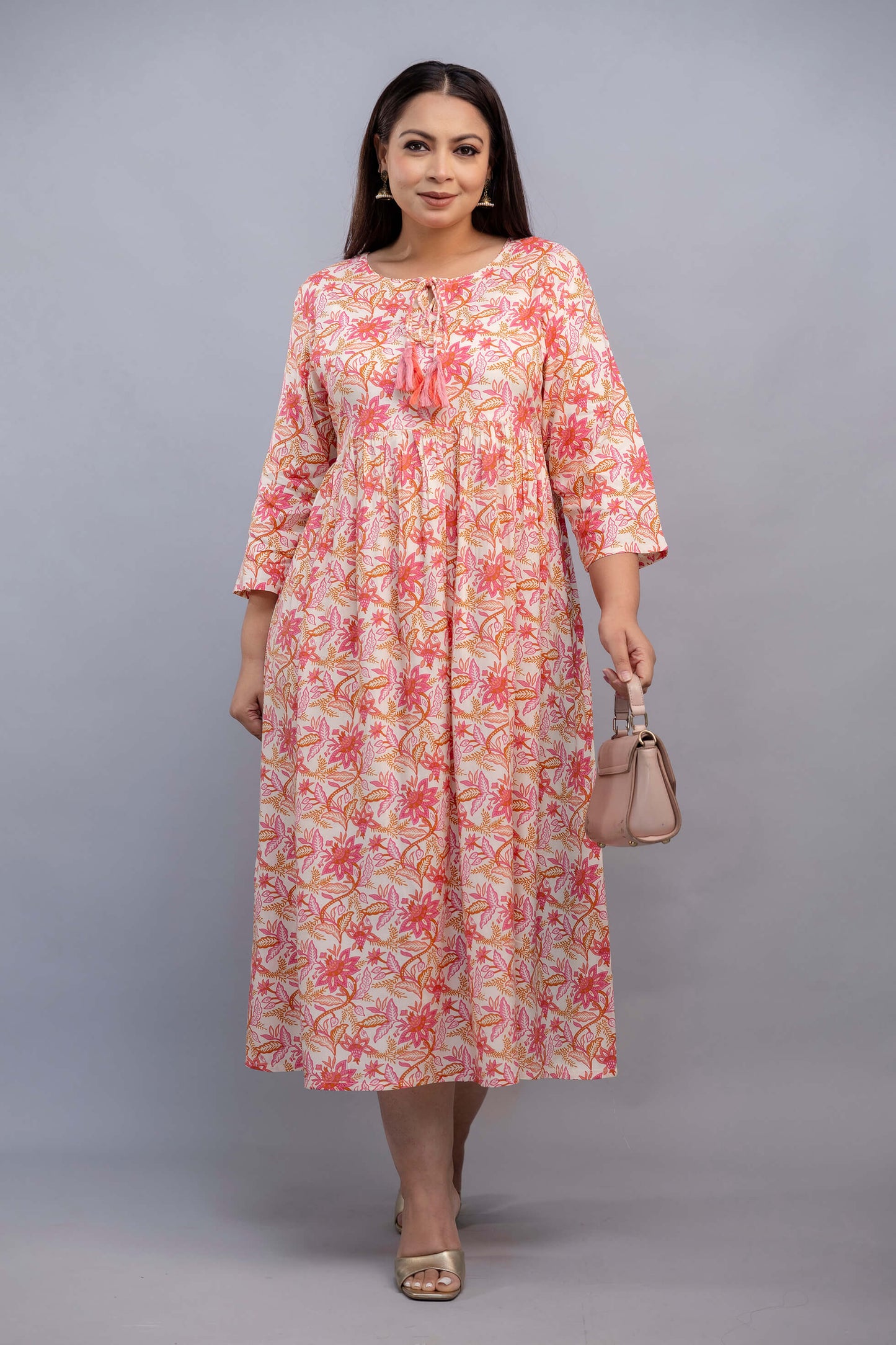 Full length pose of peach pink floral plus size rayon gathered gown for curvy women