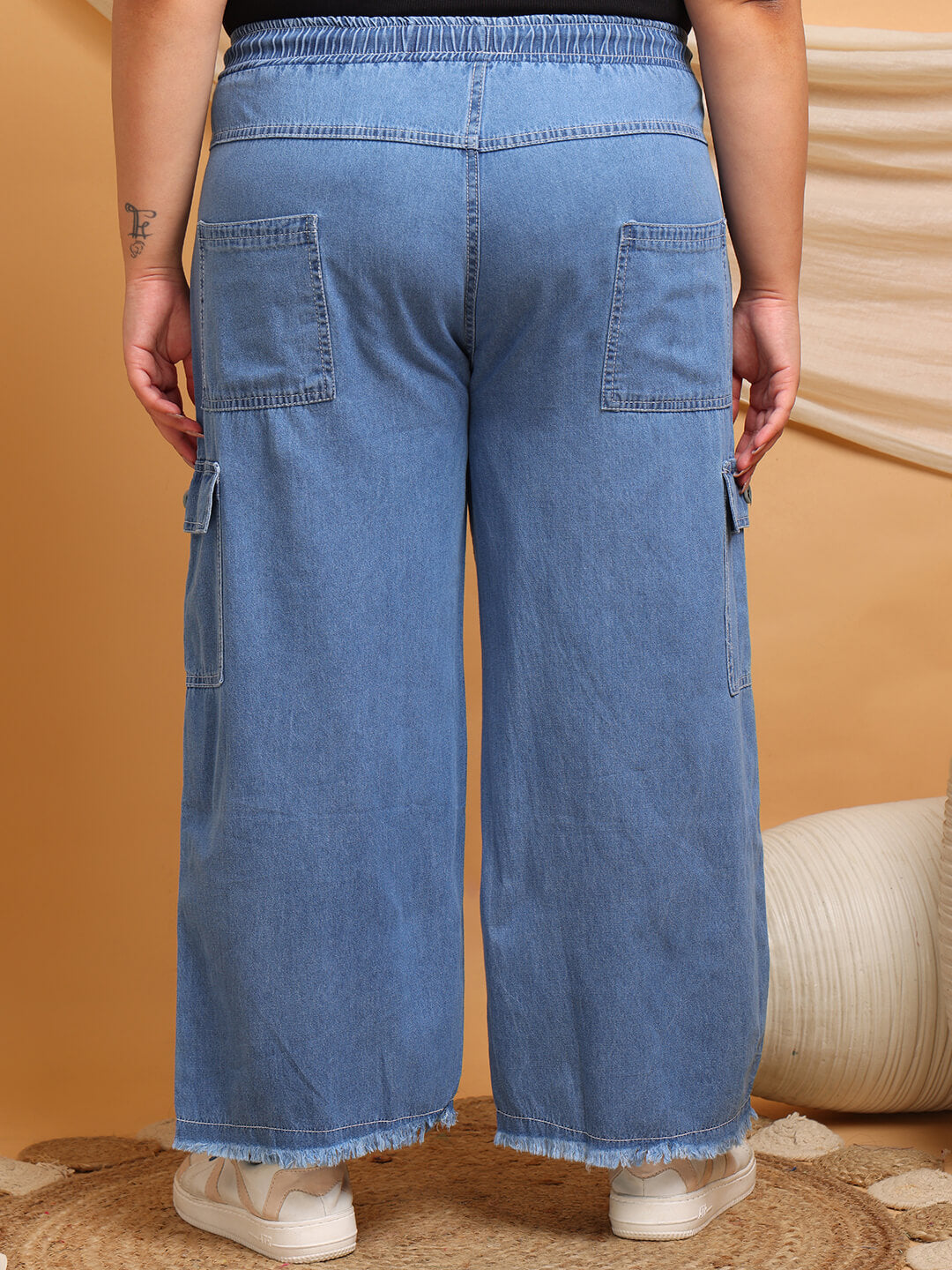 Back view of plus size denim cargo pants with elastic waistband and pockets