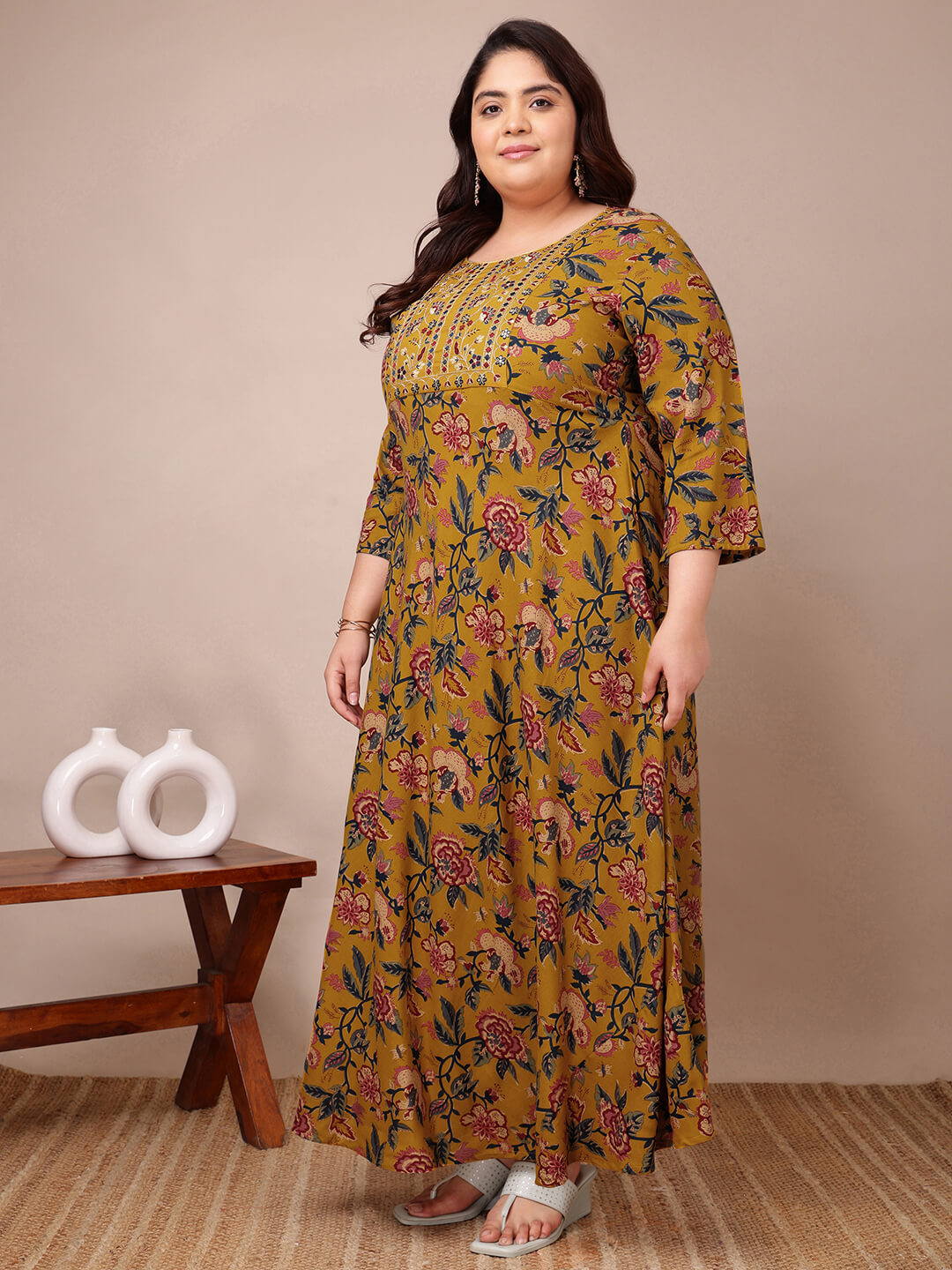 Side angle showing mustard embroidered floral gown full flare