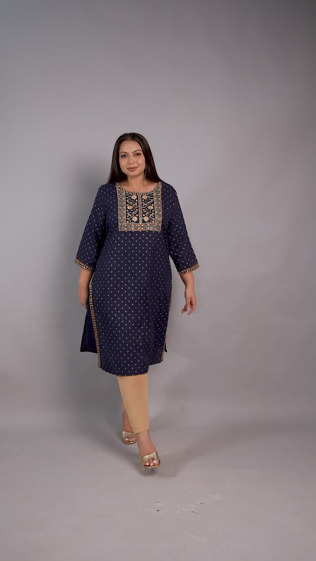 A plus-size model showcasing a Curvisha navy blue ethnic kurta with gold foil print and intricate yoke embroidery, paired with beige leggings.
