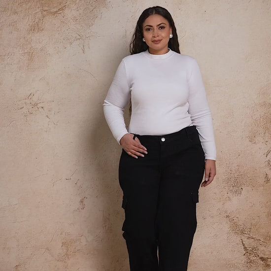 Plus size woman showcasing Curvisha buttoned black denim pants with functional side pockets and premium stitching.