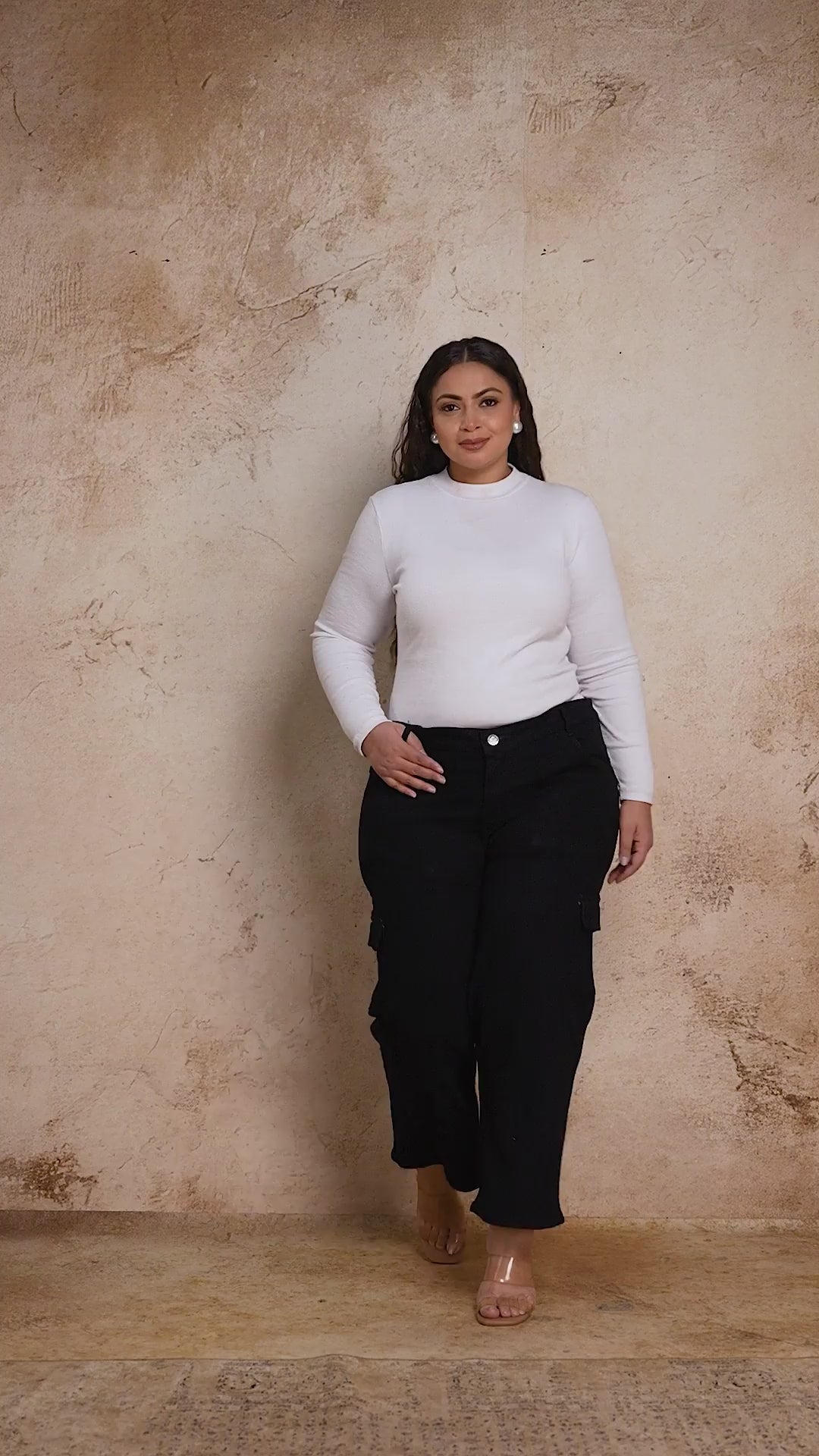 Plus size woman showcasing Curvisha buttoned black denim pants with functional side pockets and premium stitching.