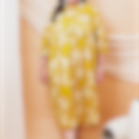 A vibrant yellow plus-size midi dress with a large white floral print and puff sleeves.