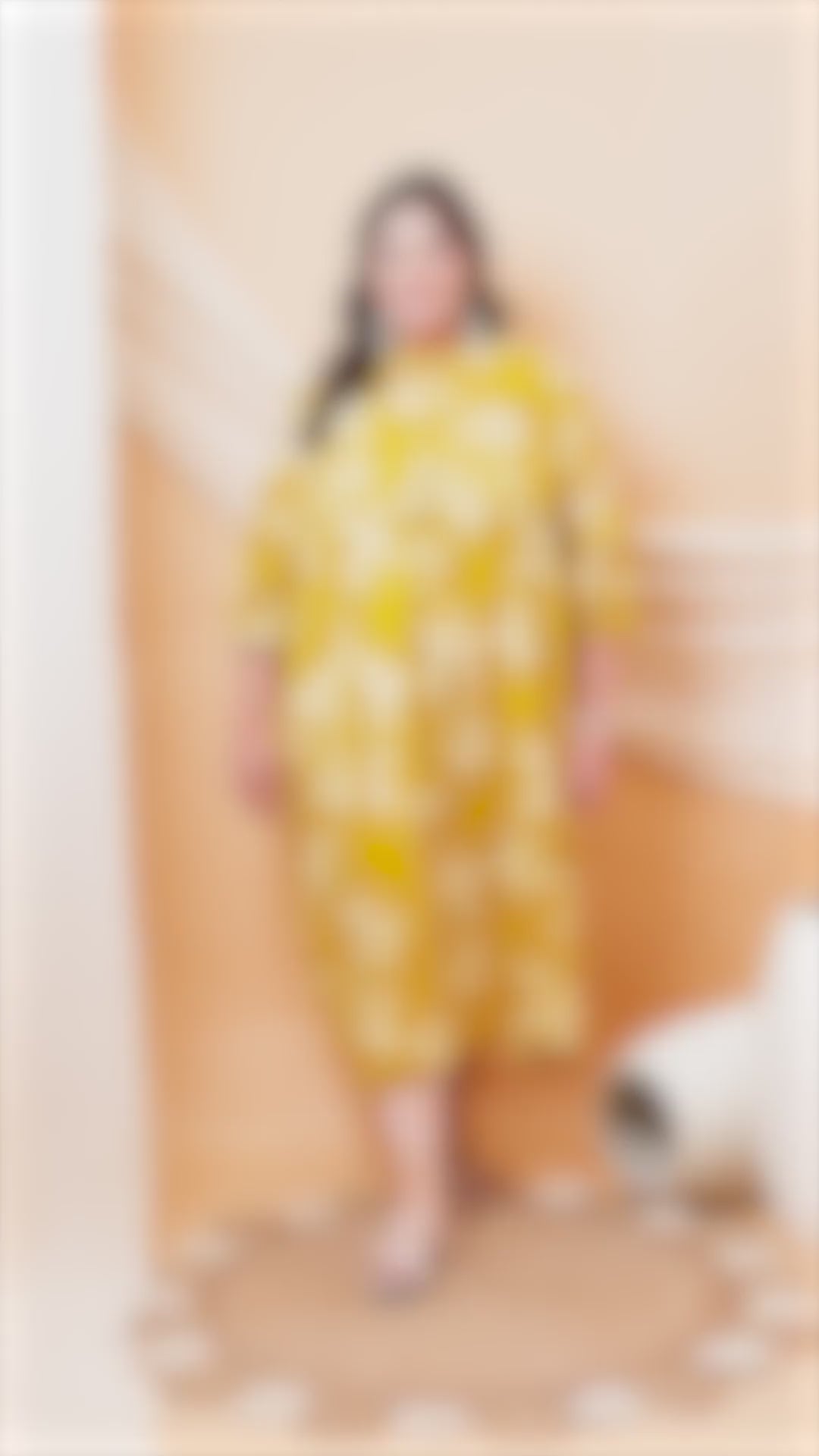 A vibrant yellow plus-size midi dress with a large white floral print and puff sleeves.